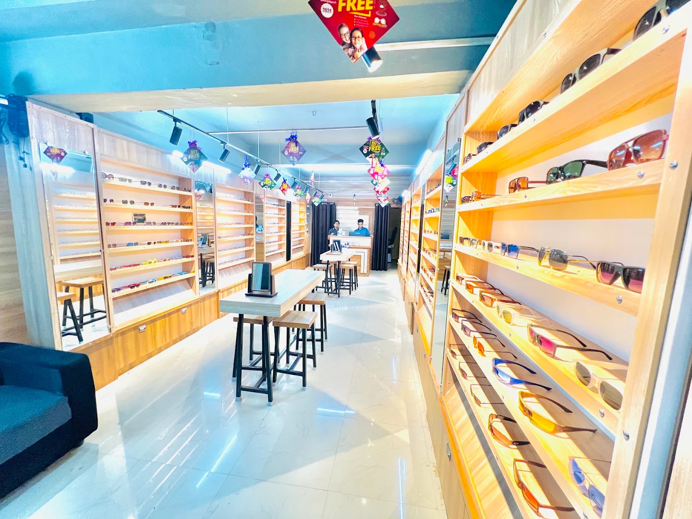 Backlit oak display walls lined with frames and sunglasses inside the Opticart Musiri showroom